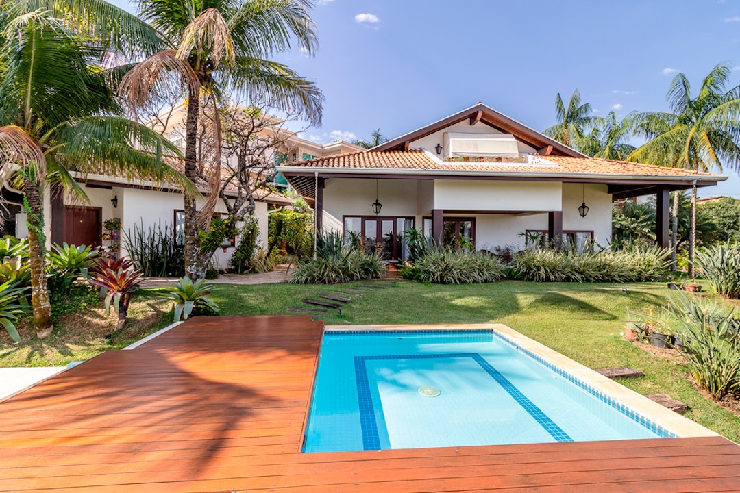 Fotografia profissional de arquitetura e interiores, imagem mostra uma piscina no fundo uma casa